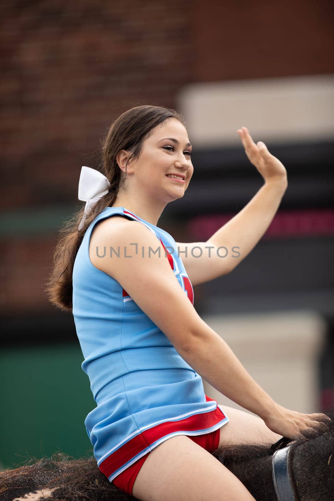 Peru, Indiana, USA - July 21, 2018 Young women riding elephants down the road at the Circus City Festival Parade