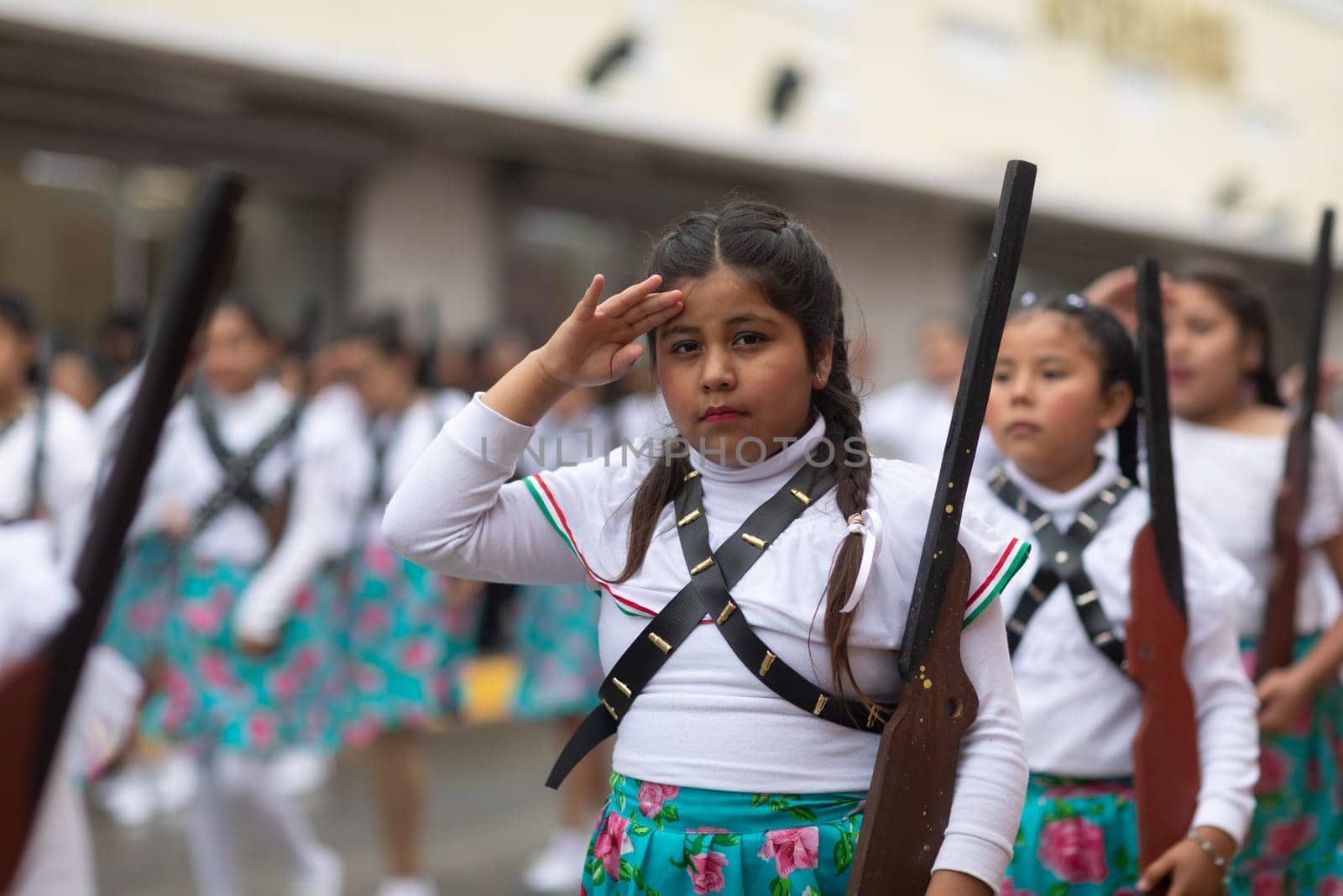 Matamoros, Tamaulipas, Mexico - November 20, 2018: The November 20 Parade, Young Girl wearing traditional clothing Holding a toy rifle at the parade