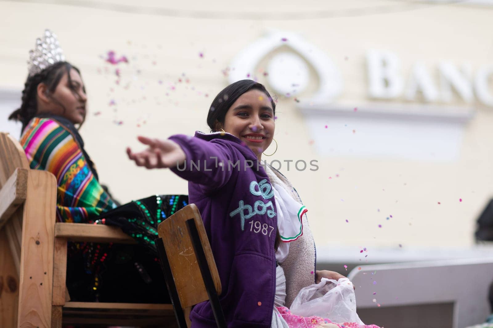 Matamoros, Tamaulipas, Mexico - November 20, 2018: The November 20 Parade, Young woman wearing traditional mexican clothing throwing confetti at the espectators
