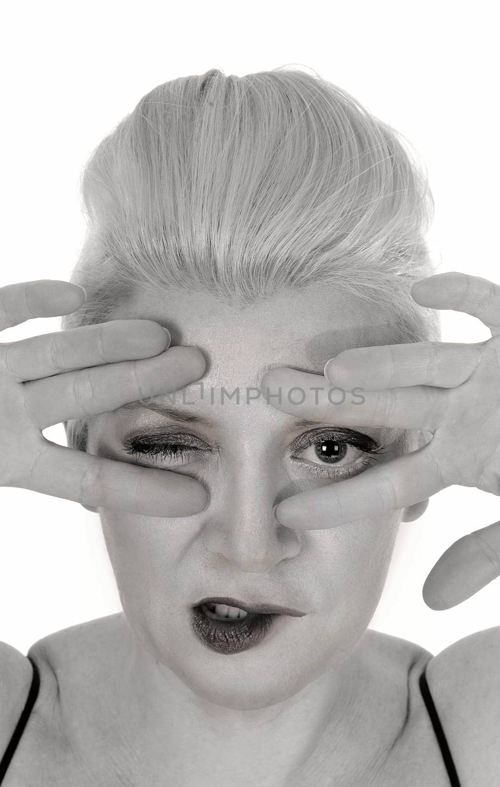 A close up portrait image of a middle age woman holding her finger.over her face, looking trough, isolated for white background.