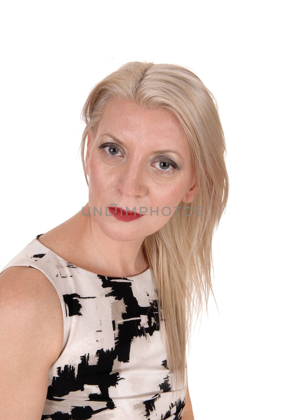 A beautiful middle age blond woman in a portrait image looking into.the camera in a summer dress, isolated for white background.