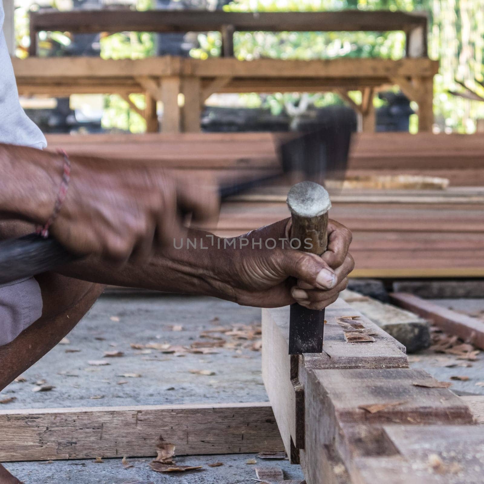 Close up of warn hands of carpenter working with manual tools in traditional carpentry shop in a third world country. Heavy labour intensive manual work.