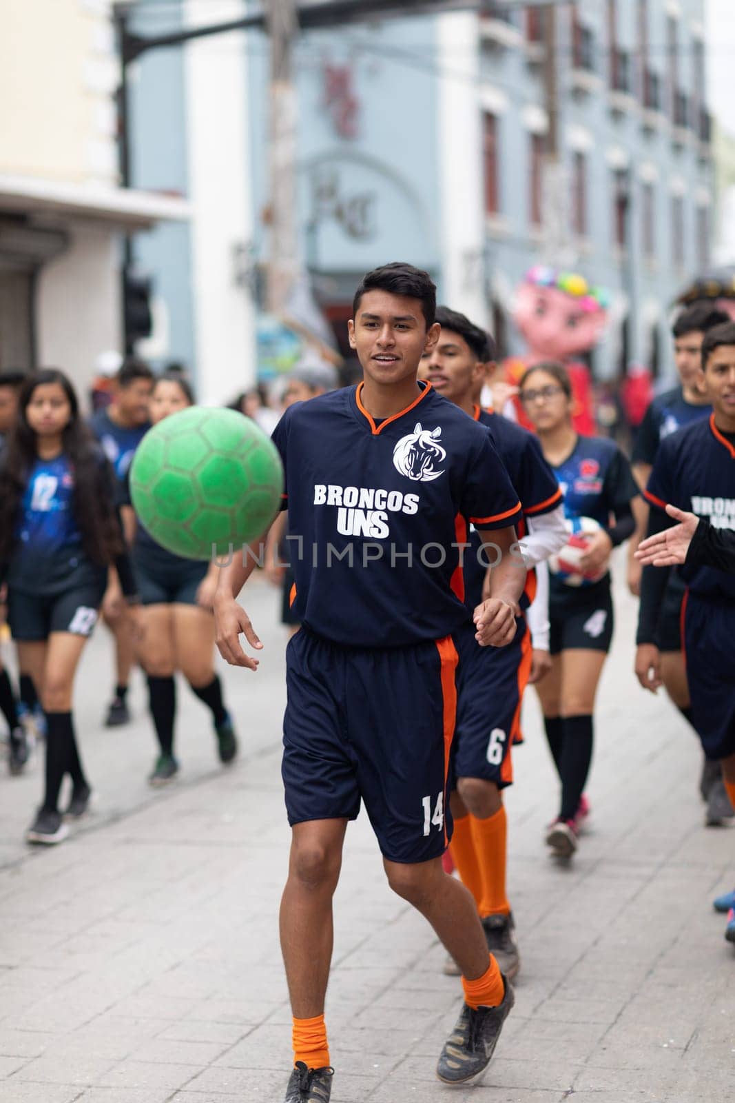 Matamoros, Tamaulipas, Mexico - November 20, 2018: The November 20 Parade, Young men playing Soccer with a green ball during the parade