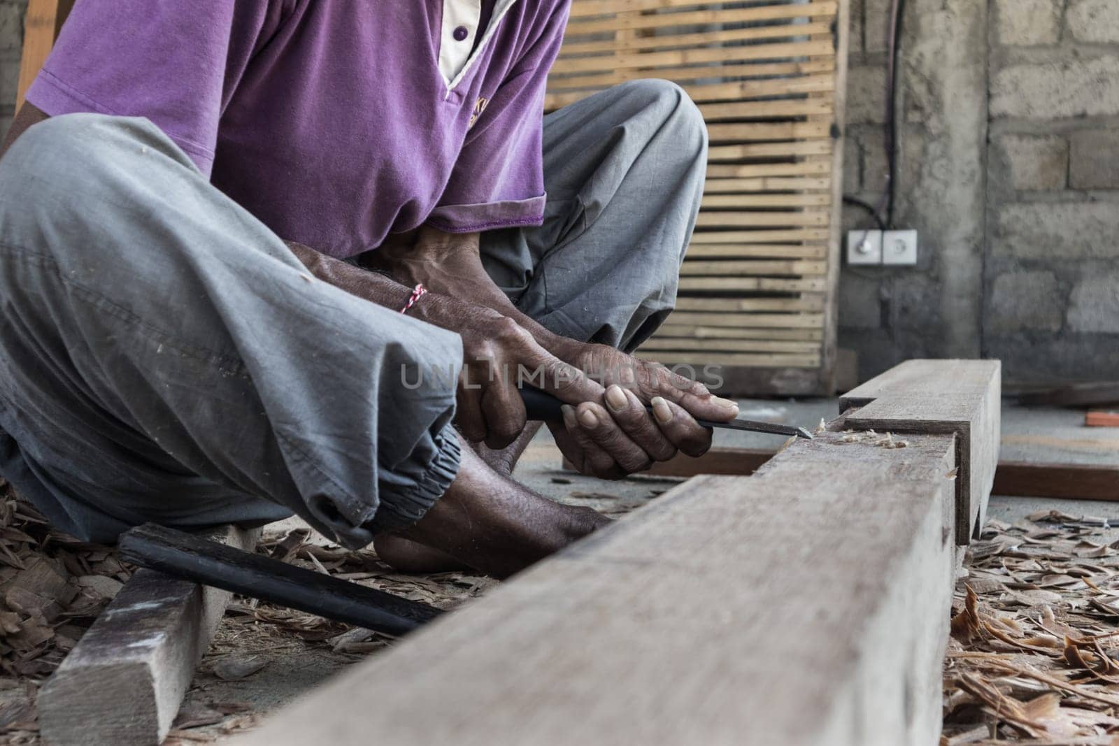 Close up of warn hands of carpenter working with manual tools in traditional carpentry shop in a third world country. Heavy labour intensive manual work.