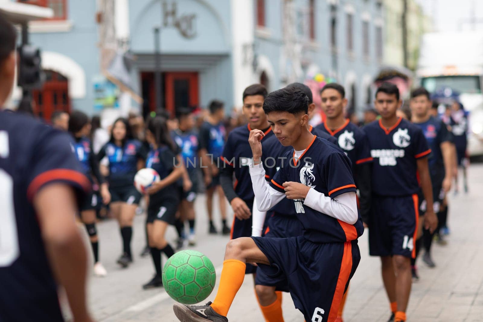 Matamoros, Tamaulipas, Mexico - November 20, 2018: The November 20 Parade, Young men playing Soccer with a green ball during the parade