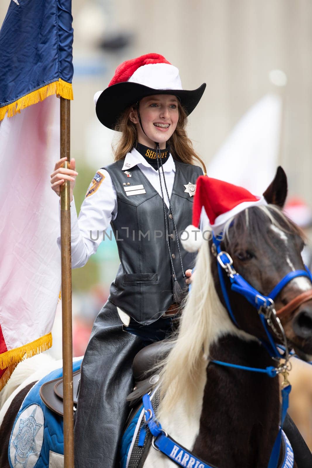 Houston, Texas, USA - November 22, 2018 The H-E-B Thanksgiving Day Parade, Woman with a Sheriff badge and Uniform riding a horse with a christmas hat