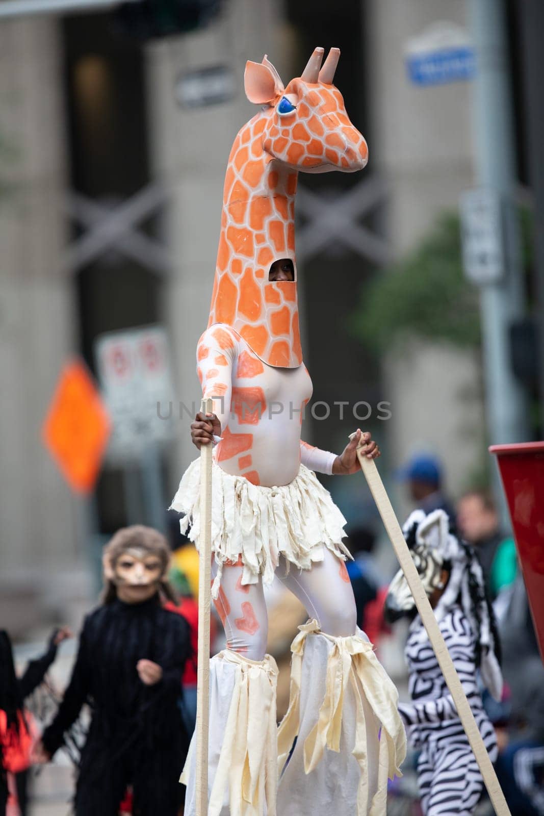 Houston, Texas, USA - November 22, 2018 The H-E-B Thanksgiving Day Parade, African American woman dress up as a giraffe on Stilts, dancing at the parade
