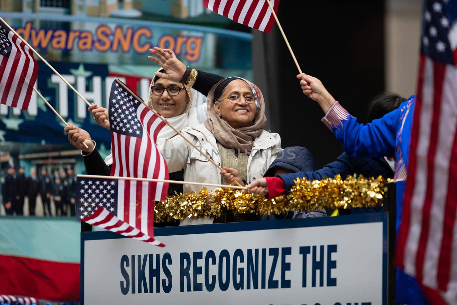 Houston, Texas, USA - November 22, 2018 The H-E-B Thanksgiving Day Parade, Women of Indian descent waving the American flag on a float