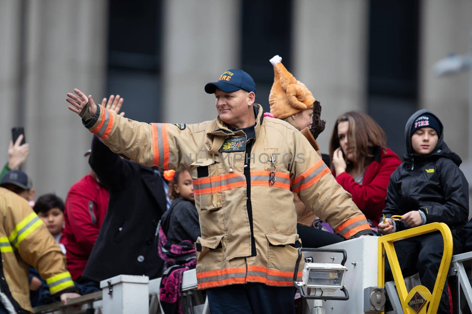 Houston, Texas, USA - November 22, 2018 The H-E-B Thanksgiving Day Parade, Firefighter on top of a firetruck waving at people