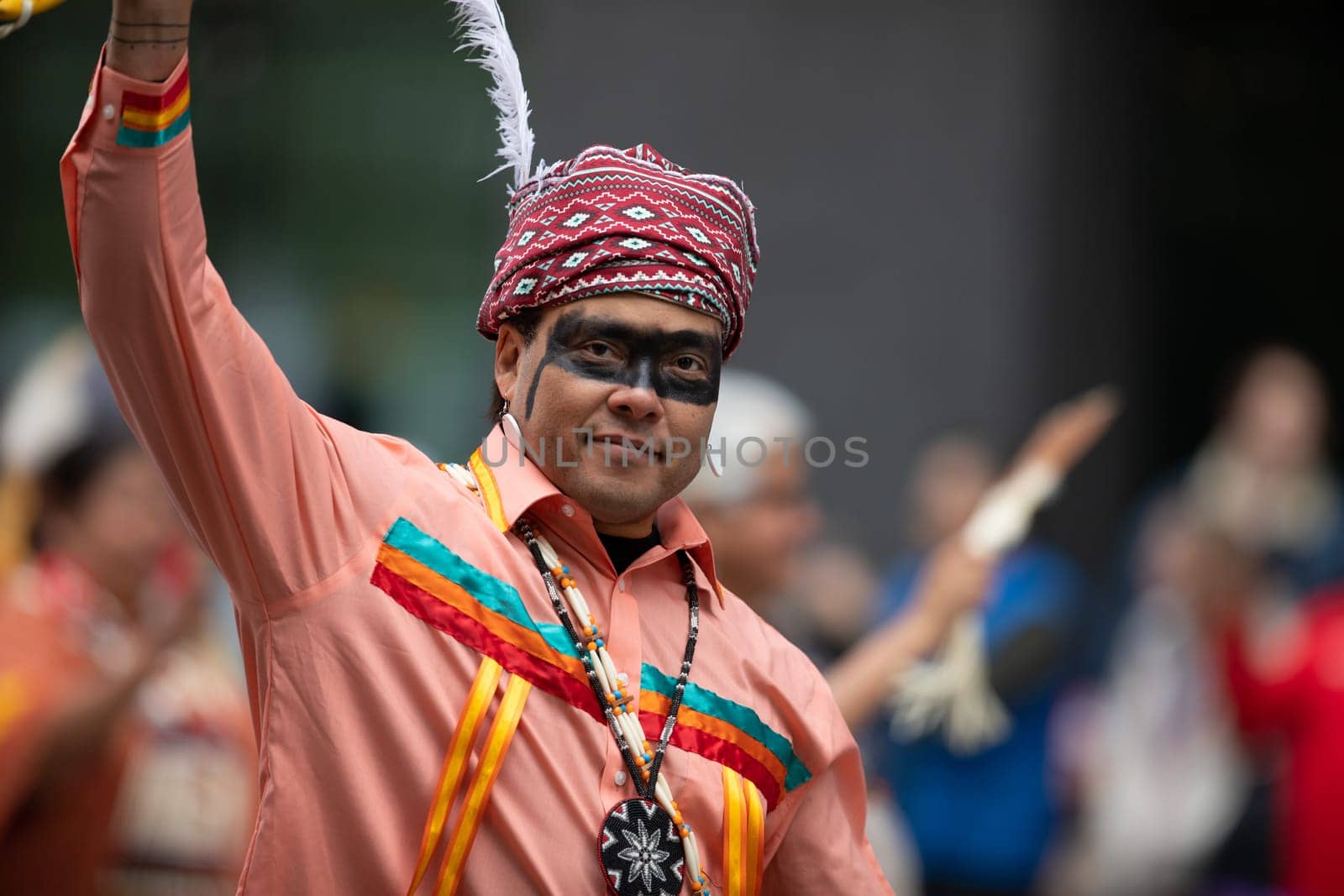 Houston, Texas, USA - November 22, 2018 The H-E-B Thanksgiving Day Parade, Native American man wearing traditional clothing waves at the camera