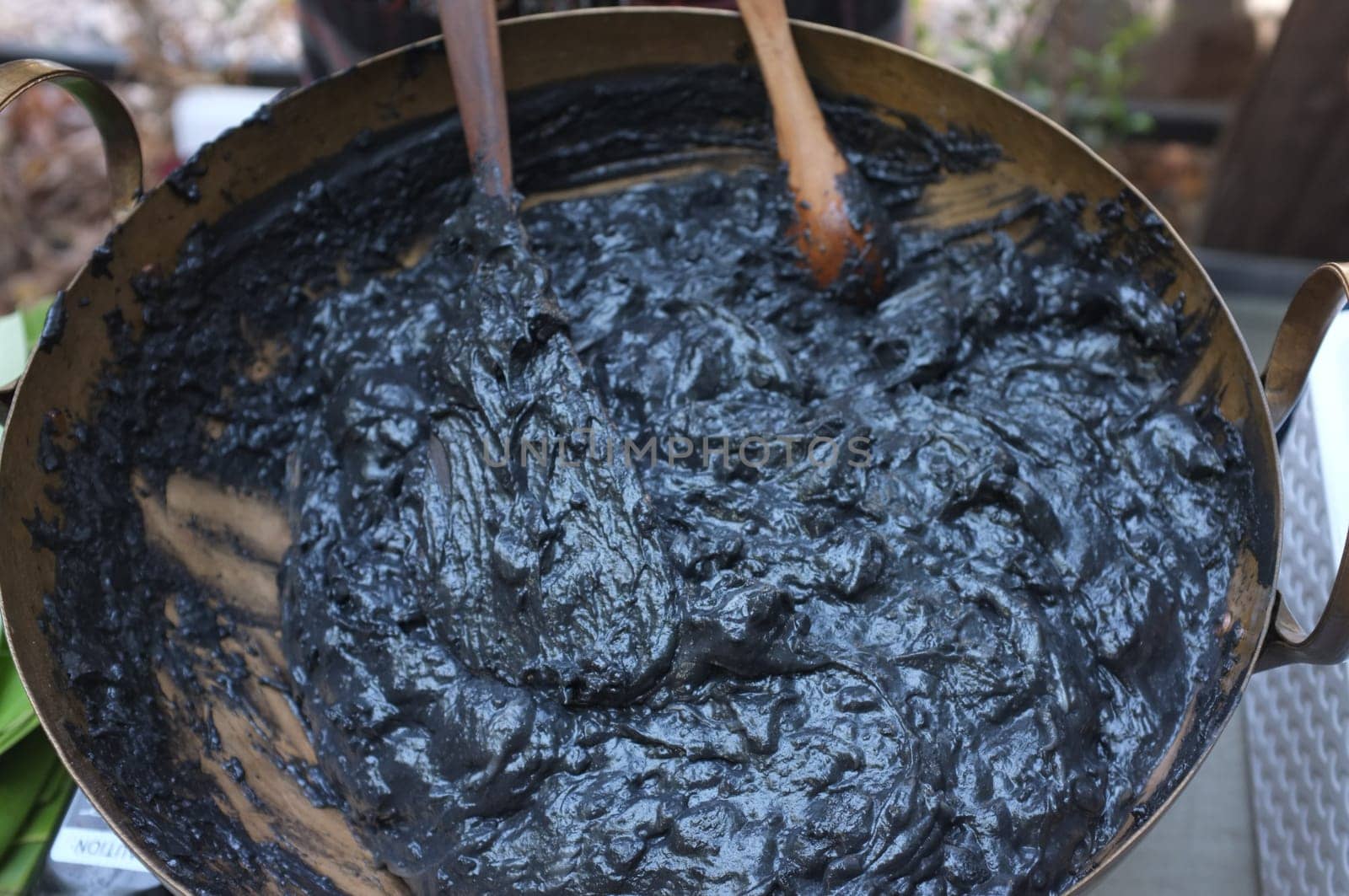 Cooking Scene of BLACK COCONUT SWEET PUDDING in Brass pot (KANOM PIAKPOON) . Thai sweetmeat