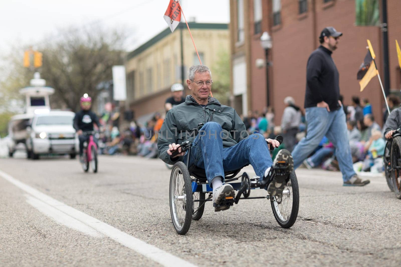 Holland, Michigan, USA - May 12, 2018 People riding trikes down the road at the Muziek Parade, during the Tulip Time Festival