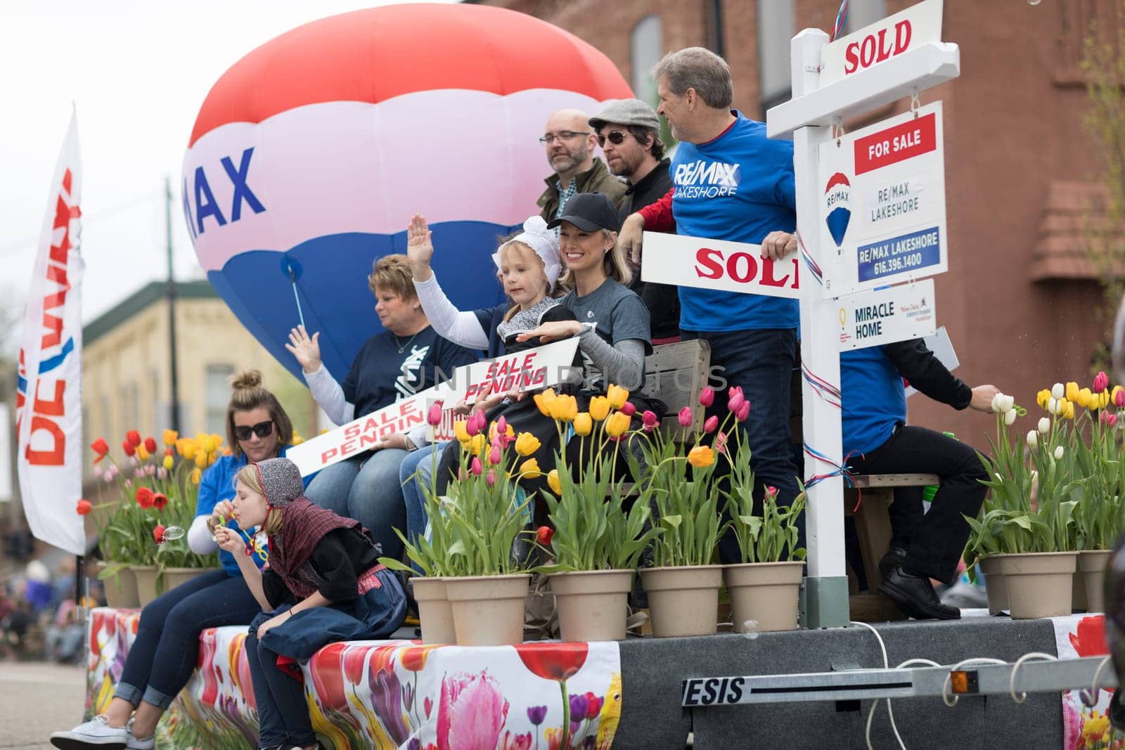 Holland, Michigan, USA - May 12, 2018 Float promoting Re/Max  with a hot air balloon and people holding signs that say, sold, sale pending at the Muziek Parade, during the Tulip Time Festival