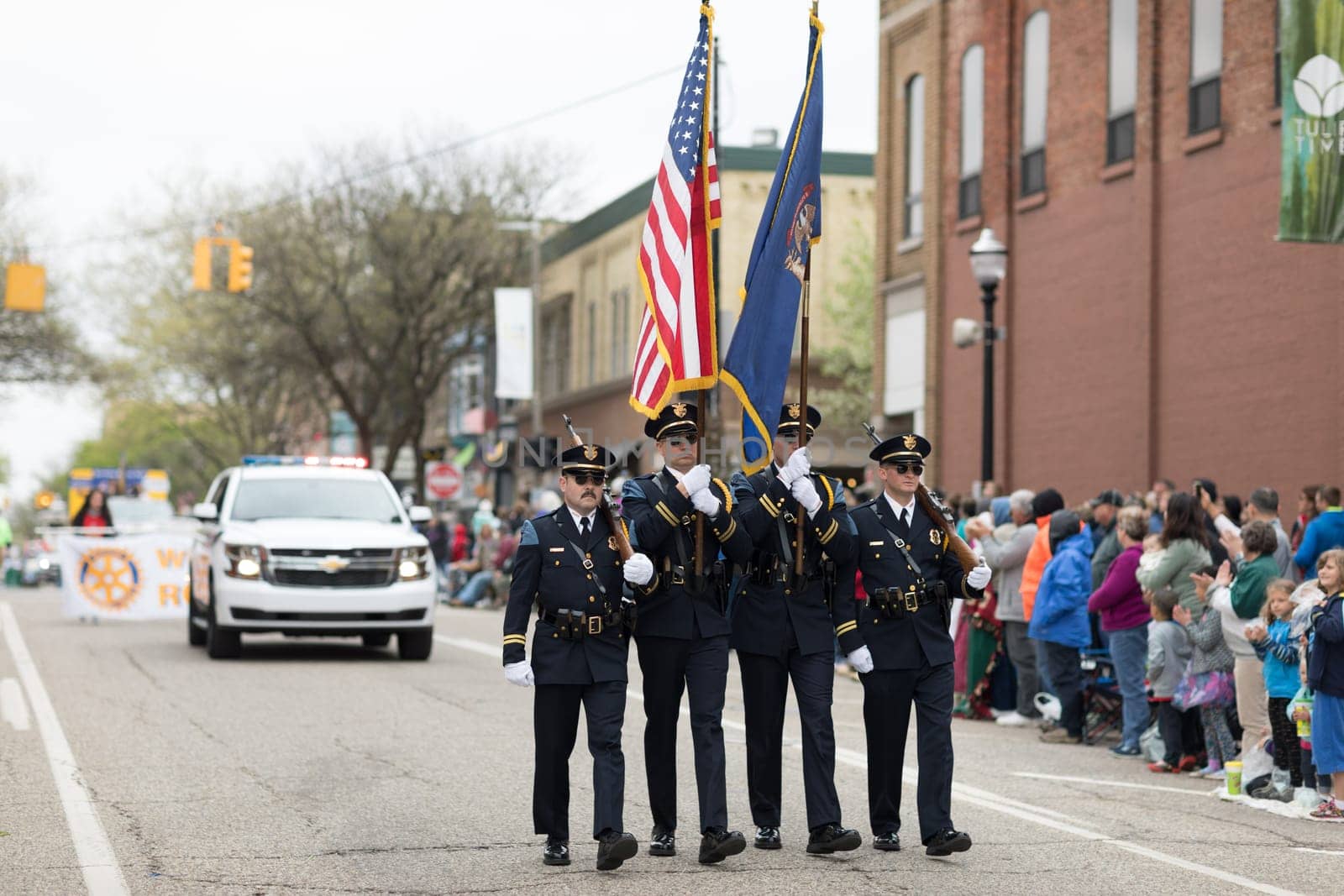 Holland, Michigan, USA - May 12, 2018 Police Officers from Holland MI carry the american flag at the Muziek Parade, during the Tulip Time Festival