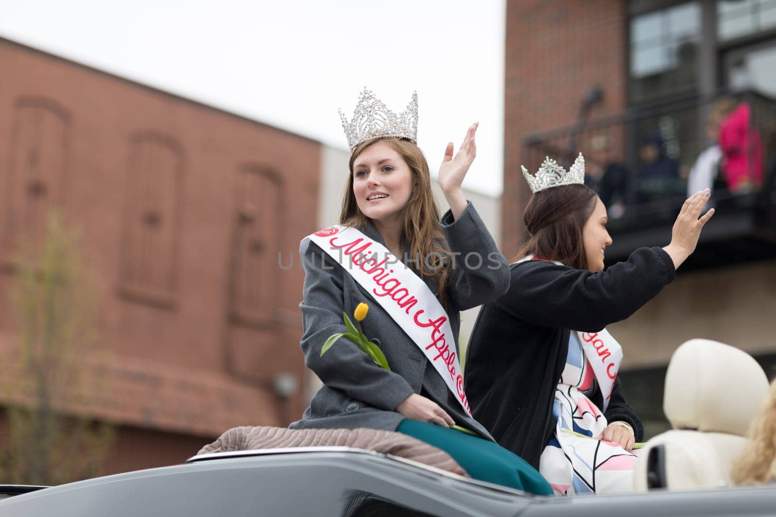 Holland, Michigan, USA - May 12, 2018 Beauty queens riding on a pontiac gto classic car at the Muziek Parade, during the Tulip Time Festival