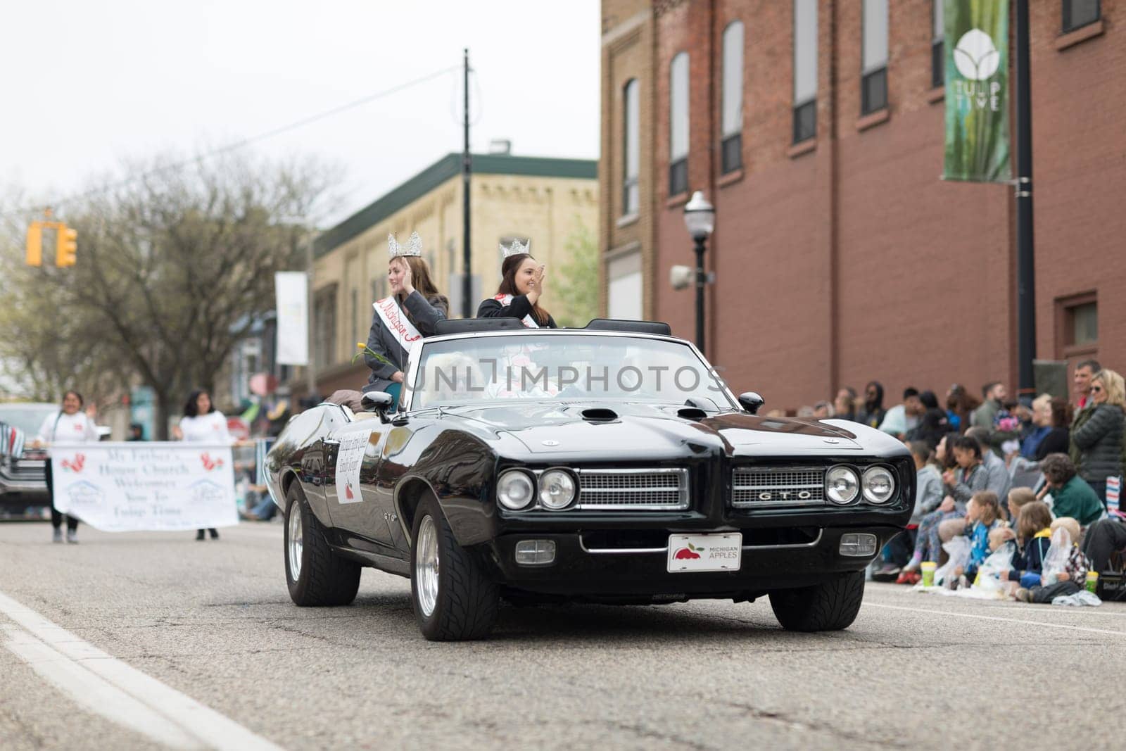 Holland, Michigan, USA - May 12, 2018 Beauty queens riding on a pontiac gto classic car at the Muziek Parade, during the Tulip Time Festival