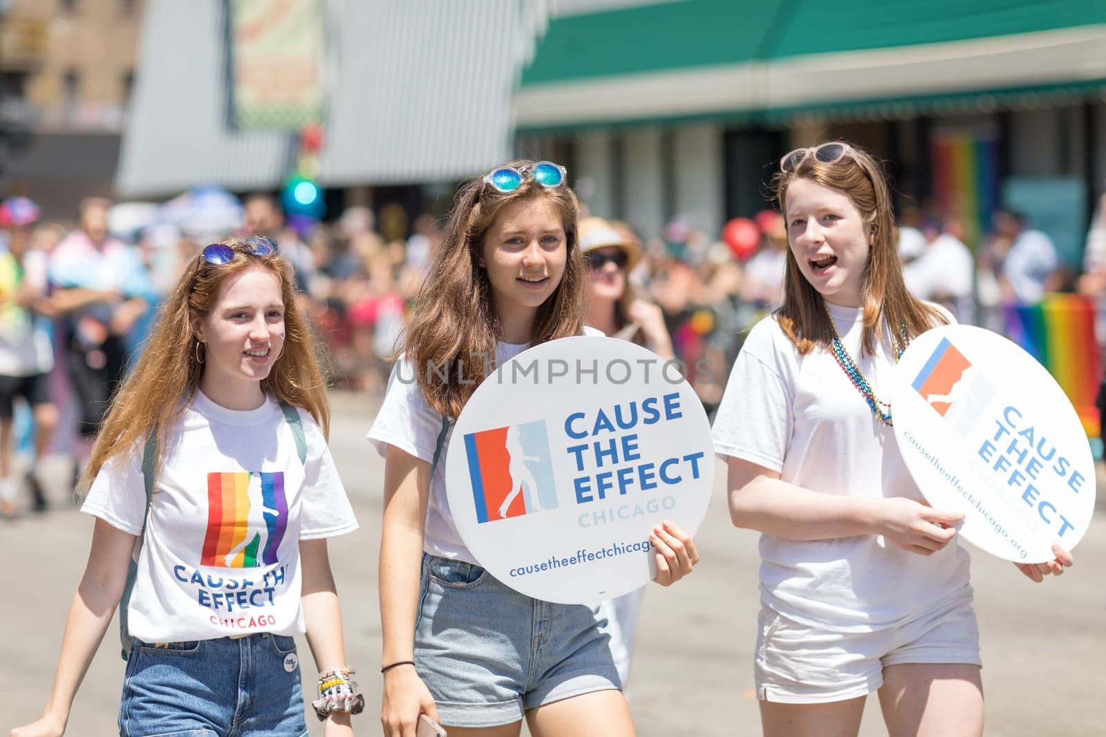 Chicago, Illinois, USA - June 24, 2018 young women carrying signs that say, Cause The Effect Chicago during the LGBTQ Pride Parade in Chicago