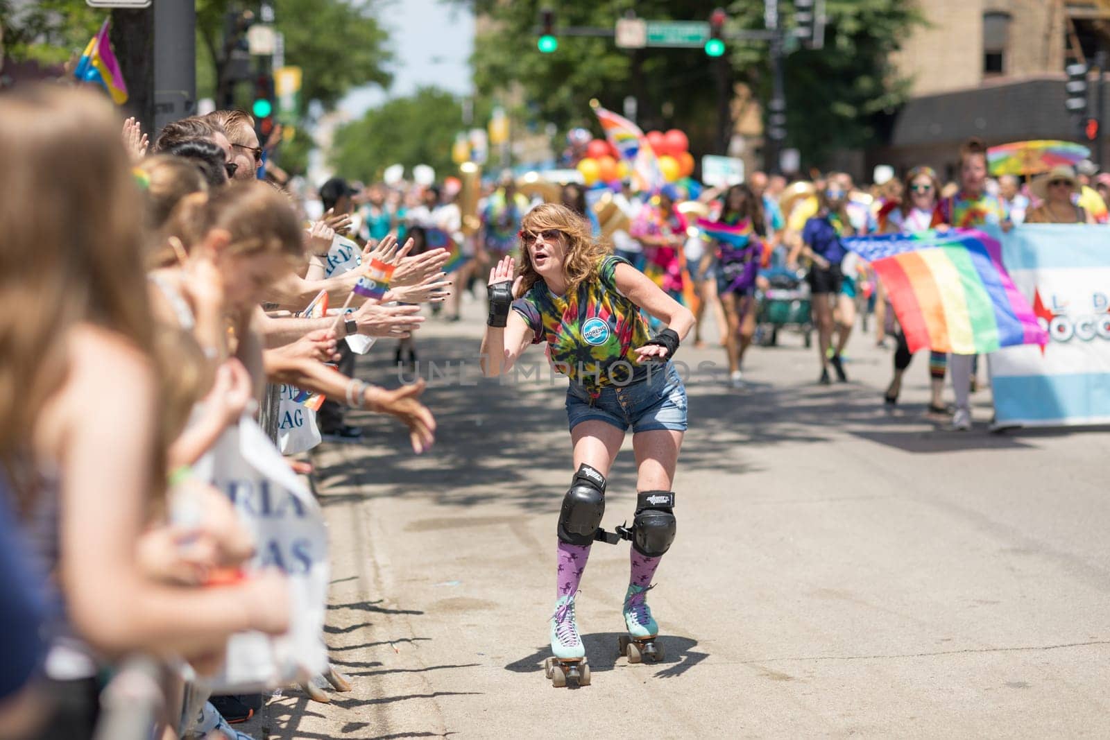 Chicago, Illinois, USA - June 24, 2018 Woman on roller skates giving the spectaors high fives during the LGBTQ Pride Parade in Chicago