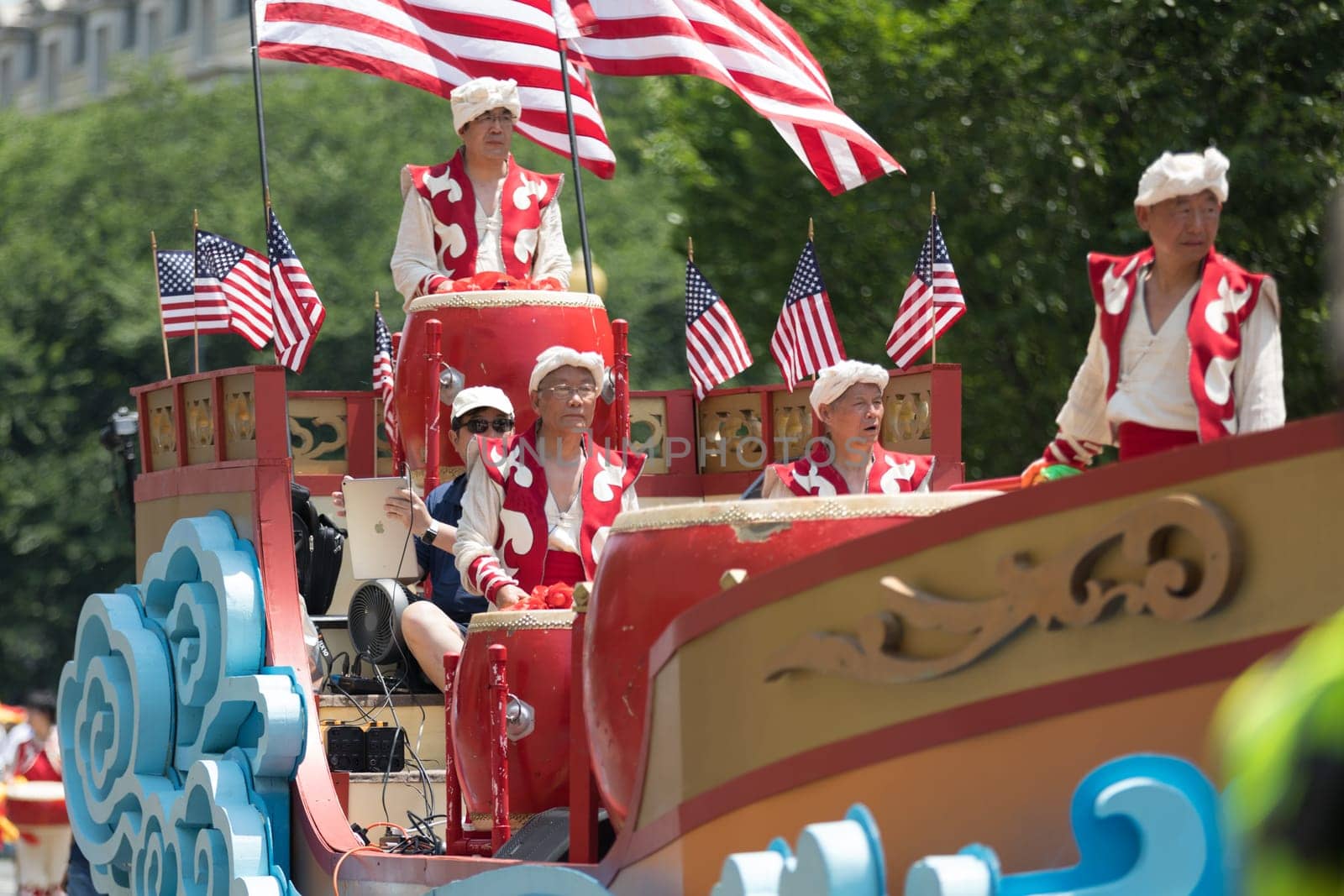 Washington, D.C., USA - July 4, 2018, The National Independence Day Parade, Chinese, wearing traditional clothing, playing drums, and with american flags, going down constitution avenue during the parade