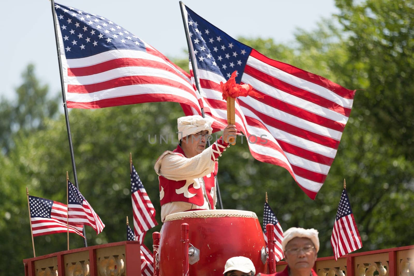 Washington, D.C., USA - July 4, 2018, The National Independence Day Parade, Chinese, wearing traditional clothing, playing drums, and with american flags, going down constitution avenue during the parade