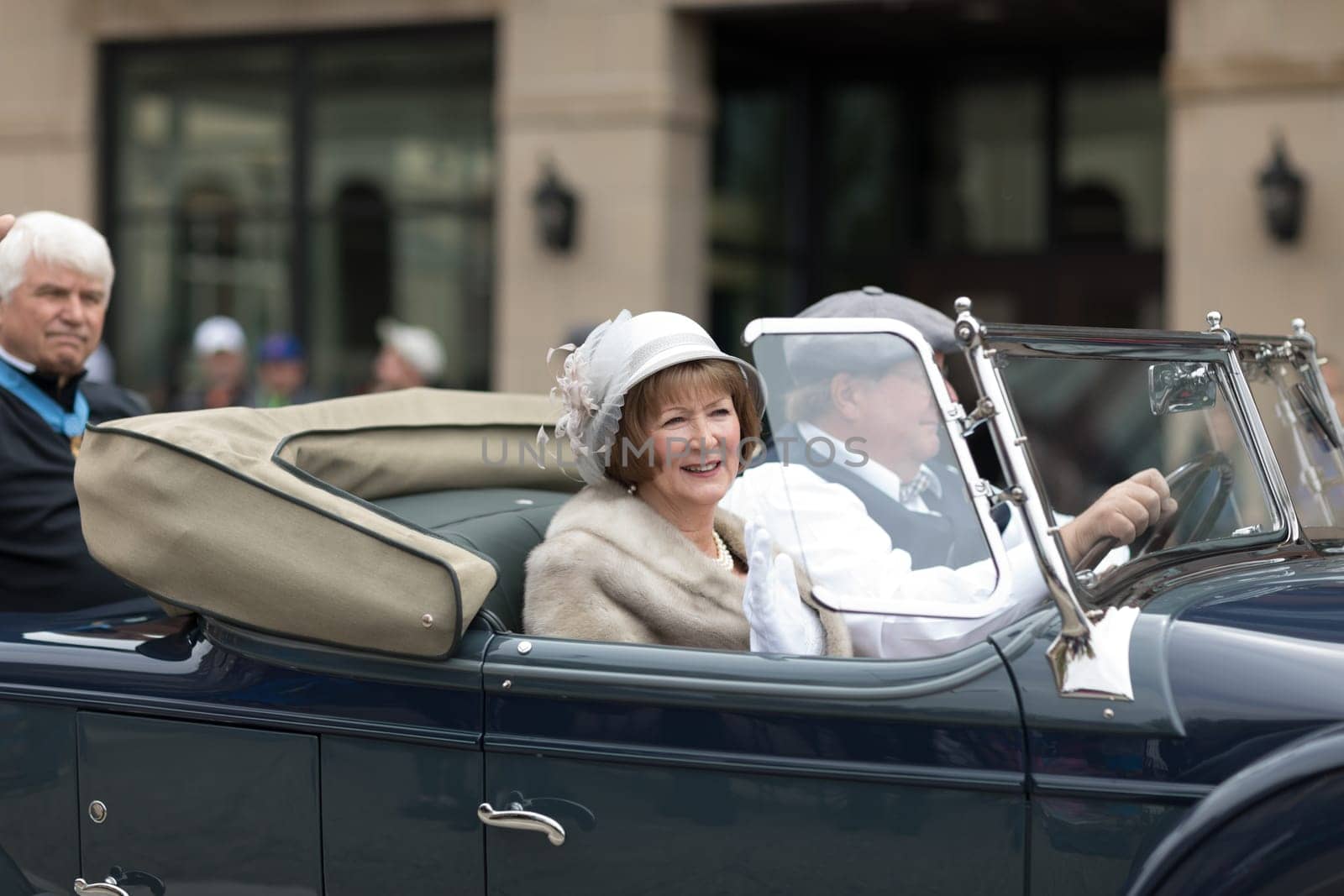 Holland, Michigan, USA - May 12, 2018 People wearing vintage clothing riading a classic car at the Muziek Parade, during the Tulip Time Festival