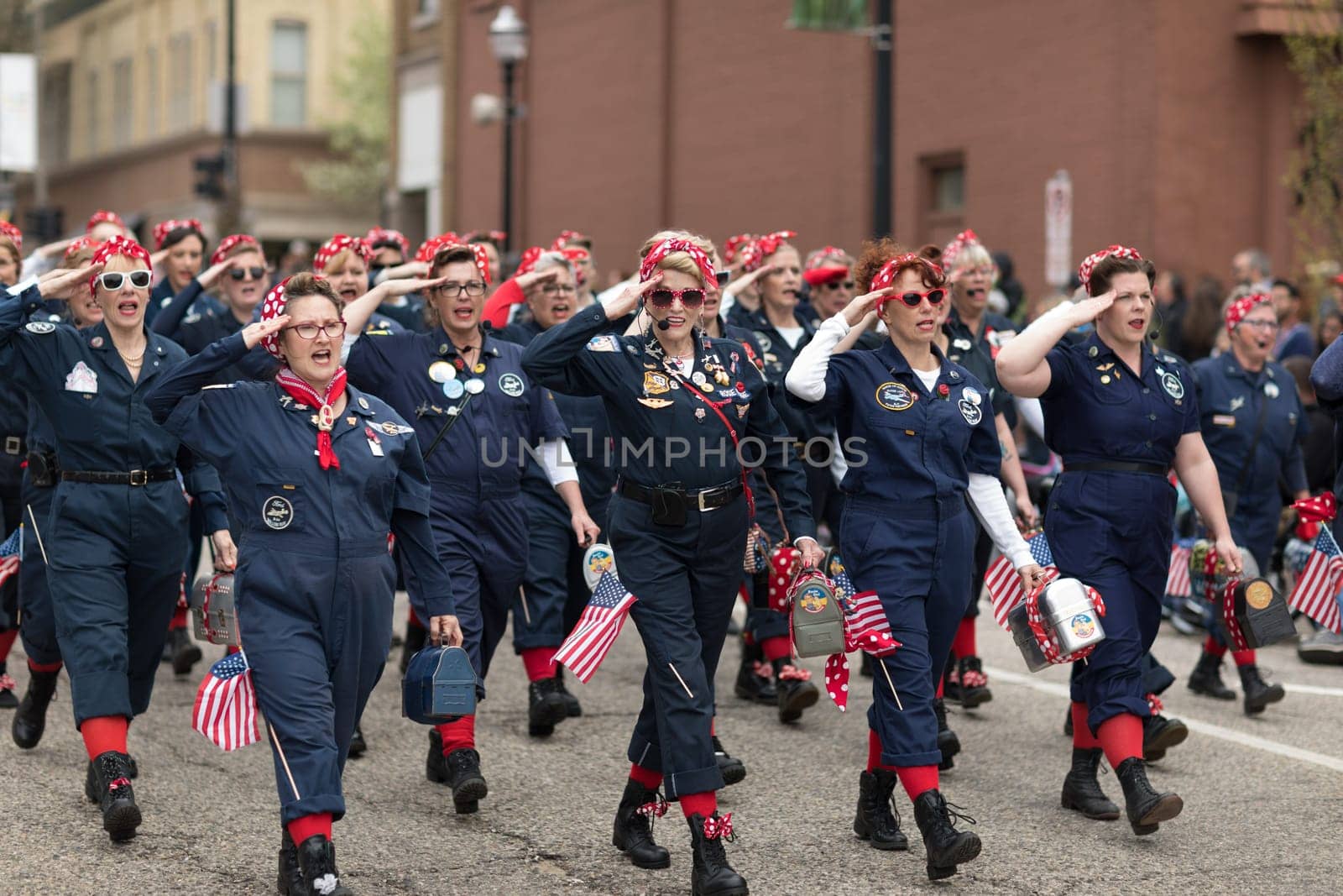 Holland, Michigan, USA - May 12, 2018 Women dress up as Rosie sing and dance at the Muziek Parade, during the Tulip Time Festival