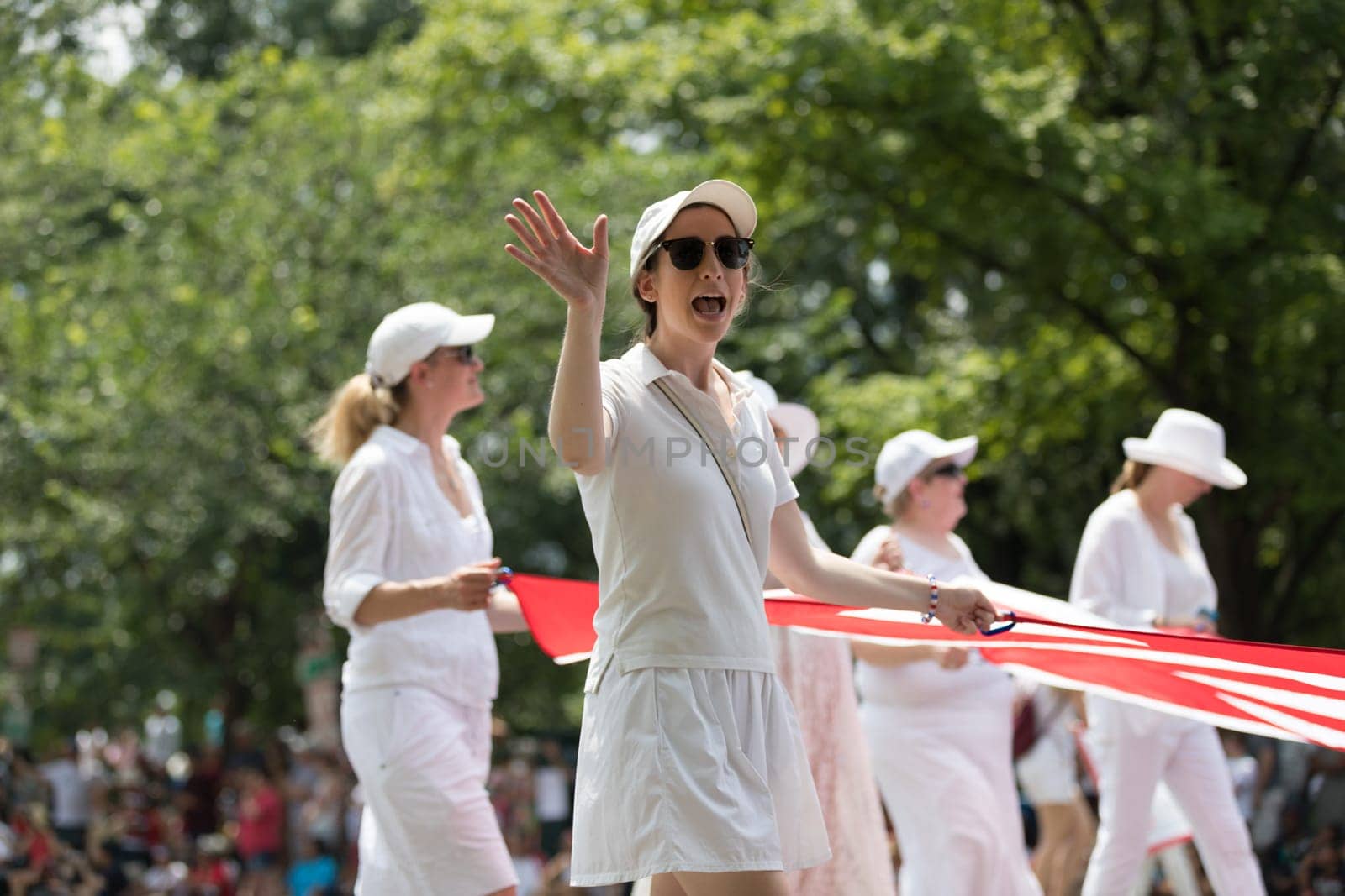 Washington, D.C., USA - July 4, 2018, The National Independence Day Parade, A group of women carrying a giant american flag down constitution avenue
