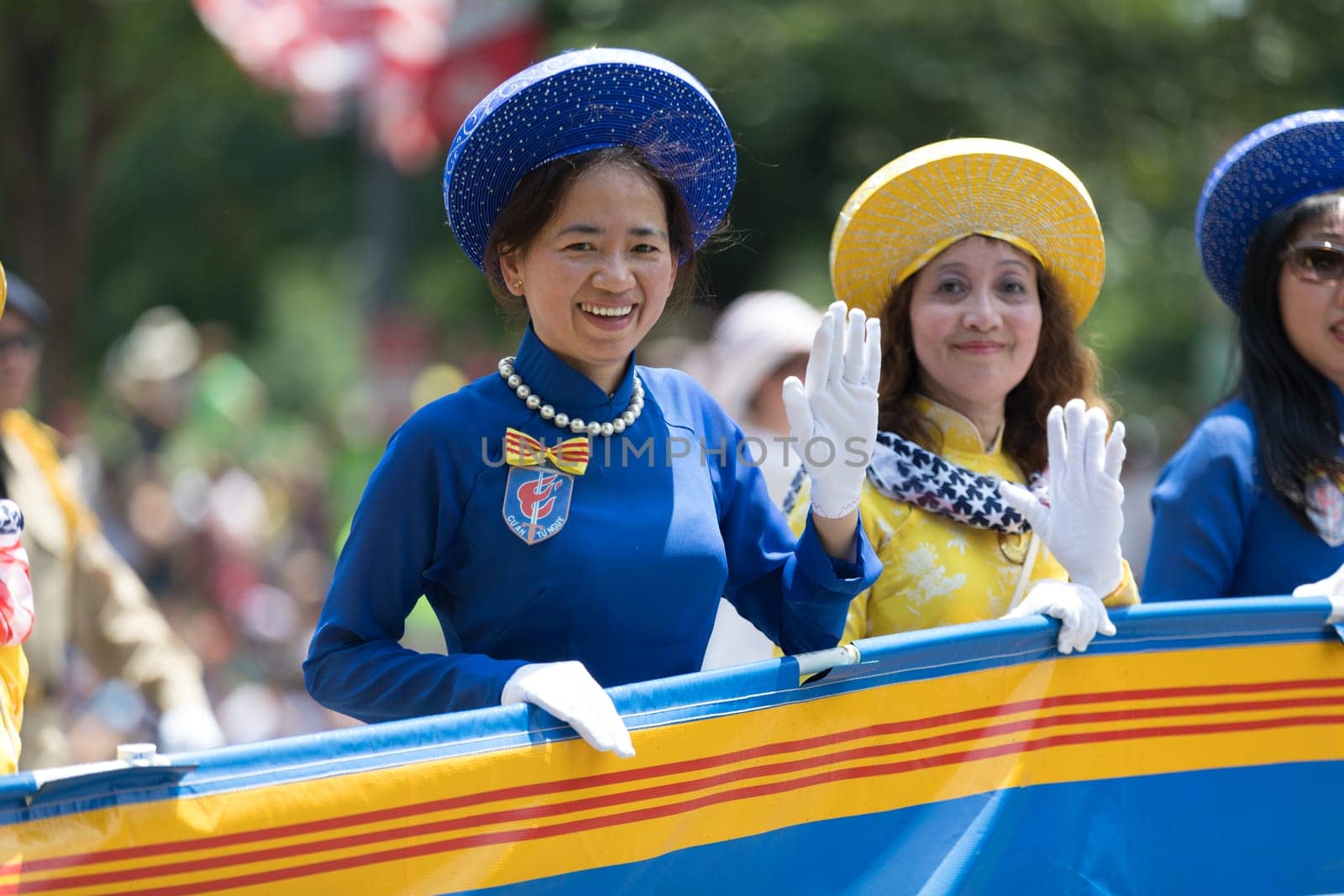 Washington, D.C., USA - July 4, 2018, The National Independence Day Parade, Vietnamese American women wearing traditional dresses, going down constitution avenue