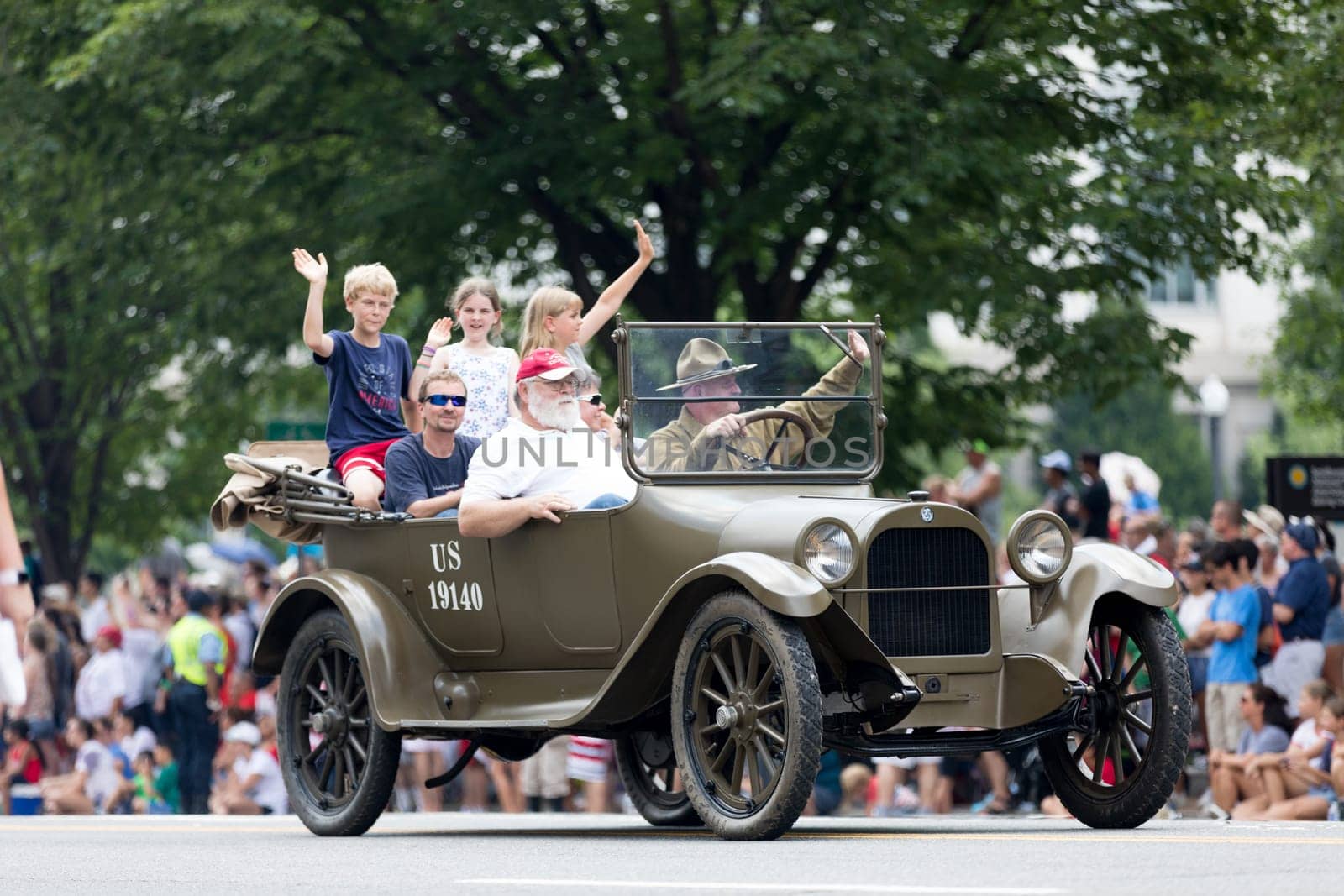 Washington, D.C., USA - July 4, 2018, The National Independence Day Parade, An old world war one military vehicle, carrying a family, going down constitution avenue