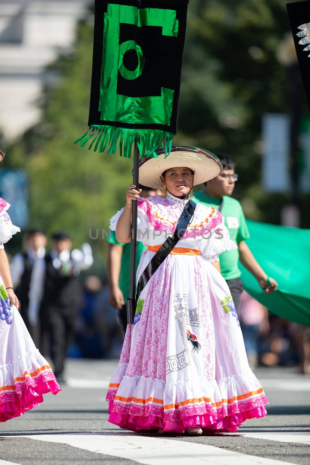 Washington, D.C., USA - September 29, 2018: The Fiesta DC Parade, Woman wearing traditional clothing from Mexico carrying a banner