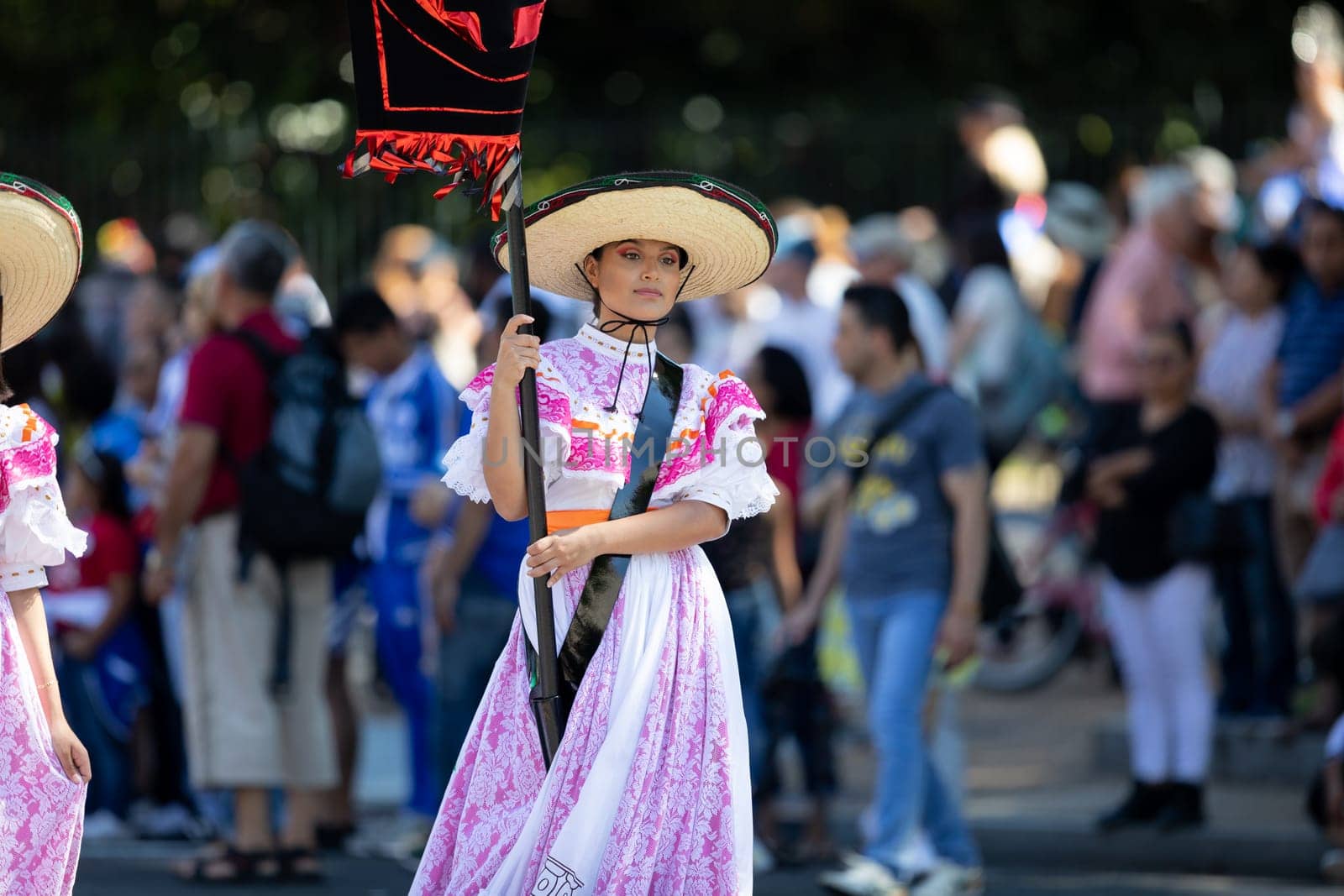 Washington, D.C., USA - September 29, 2018: The Fiesta DC Parade, Woman wearing traditional clothing from Mexico carrying a banner