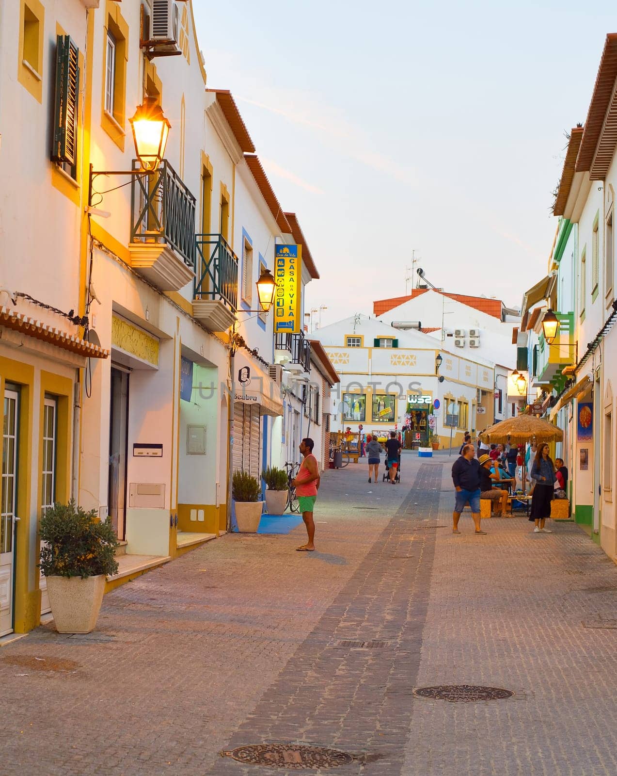 VILLA NVA DE MILFONTES - SEPTEMBER 23, 2018: People at a shopping street of Villa Nova de Milfontes - famous tourist destination in Portugal