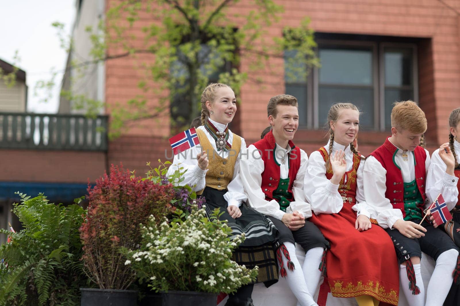 Stoughton, Wisconsin, USA - May 20, 2018: Annual Norwegian Parade, Men and women, dancers, wearing traditional norwegian clothing, being transported on a trailer