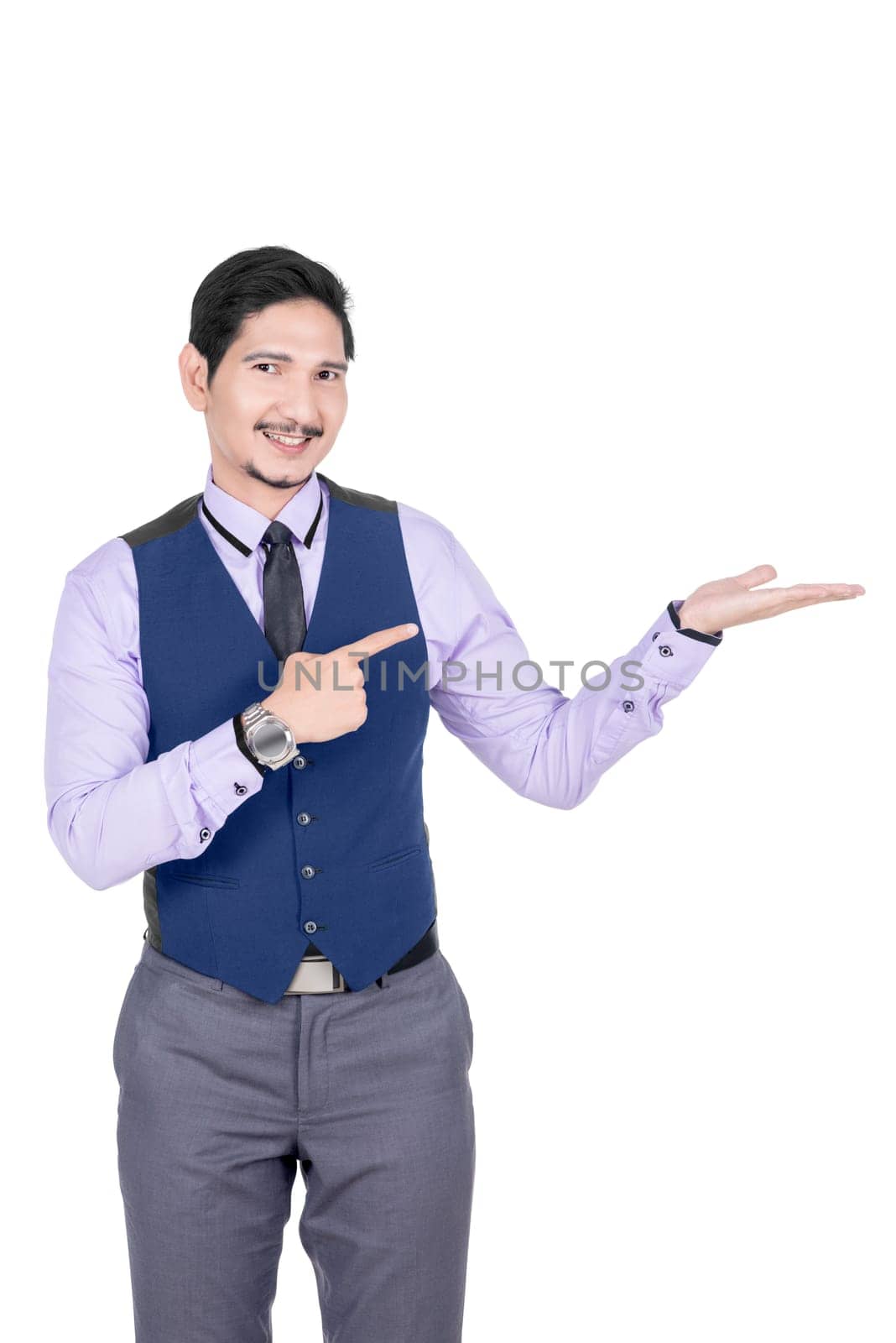 Young asian businessman pointing his open palm posing isolated over white background