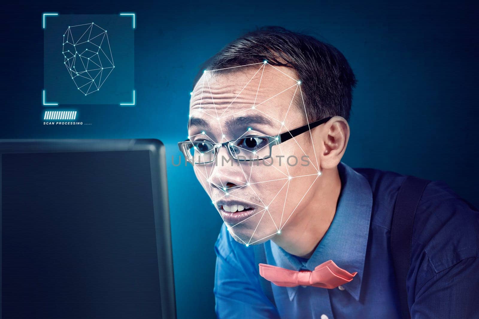Attractive asian businessman with laptop using face recognition over blue background. Modern technology concept