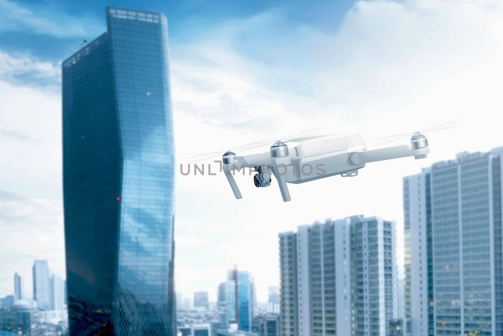 White drone with camera flying over the city with skyscrapers and blue sky background