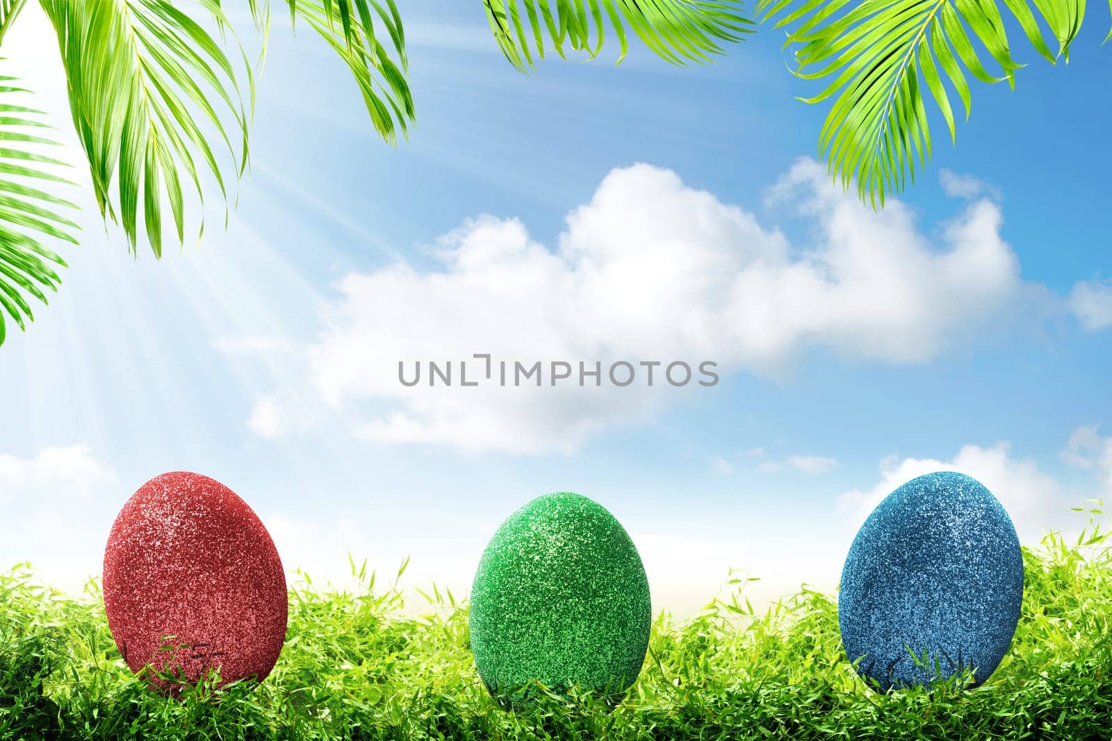 Colorful easter eggs on the green grass with palm branches and blue sky background. Happy Easter