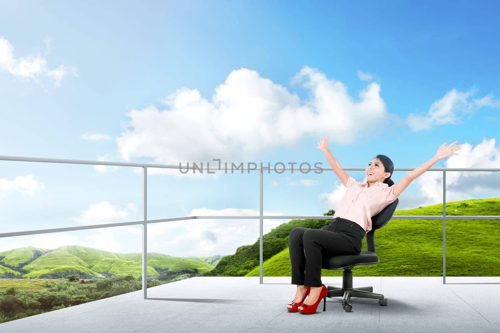 Pretty asian business woman sitting on the chair and relaxing on the terrace with green landscapes view and blue sky background