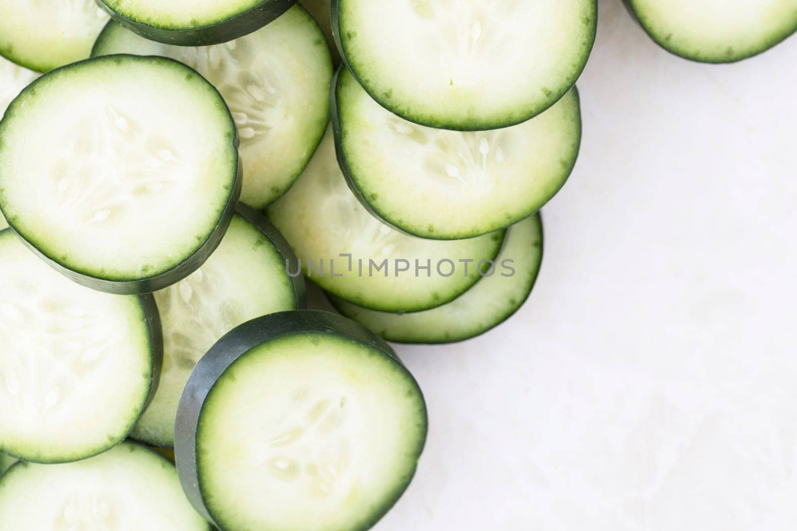 Cucumber slices on marble, flat lay with copy space