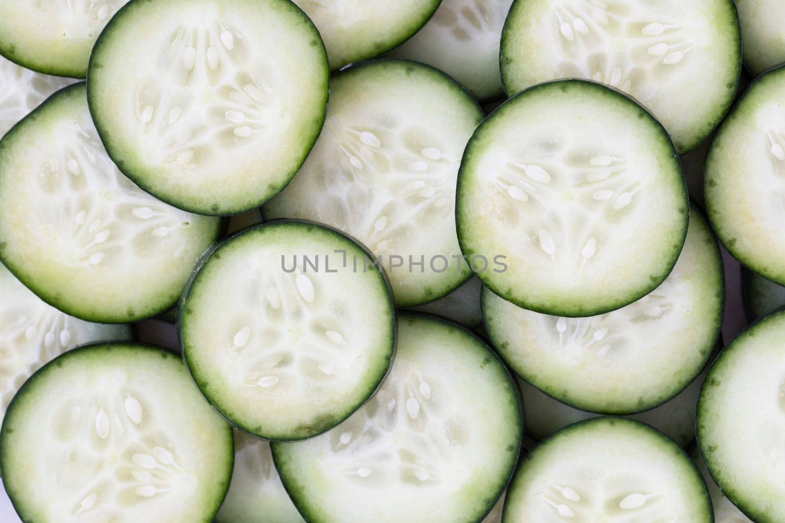 Cucumber slices filling frame for food background.