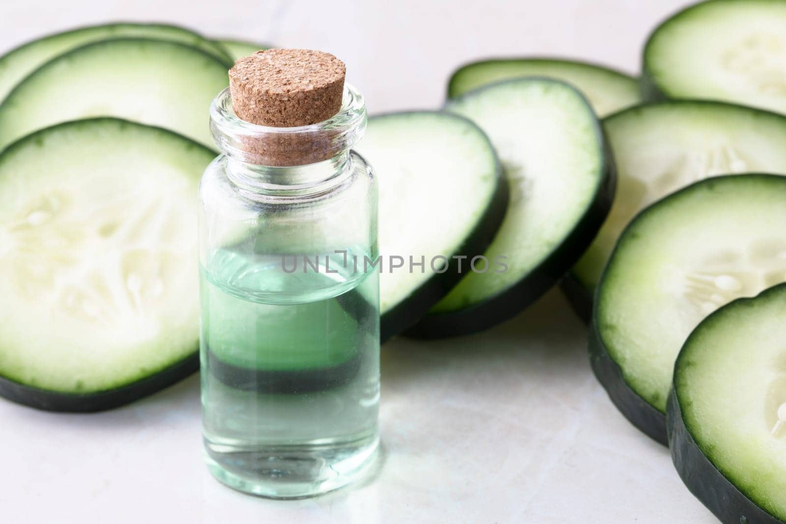 Cucumber slices and small bottle of cucumber extract.