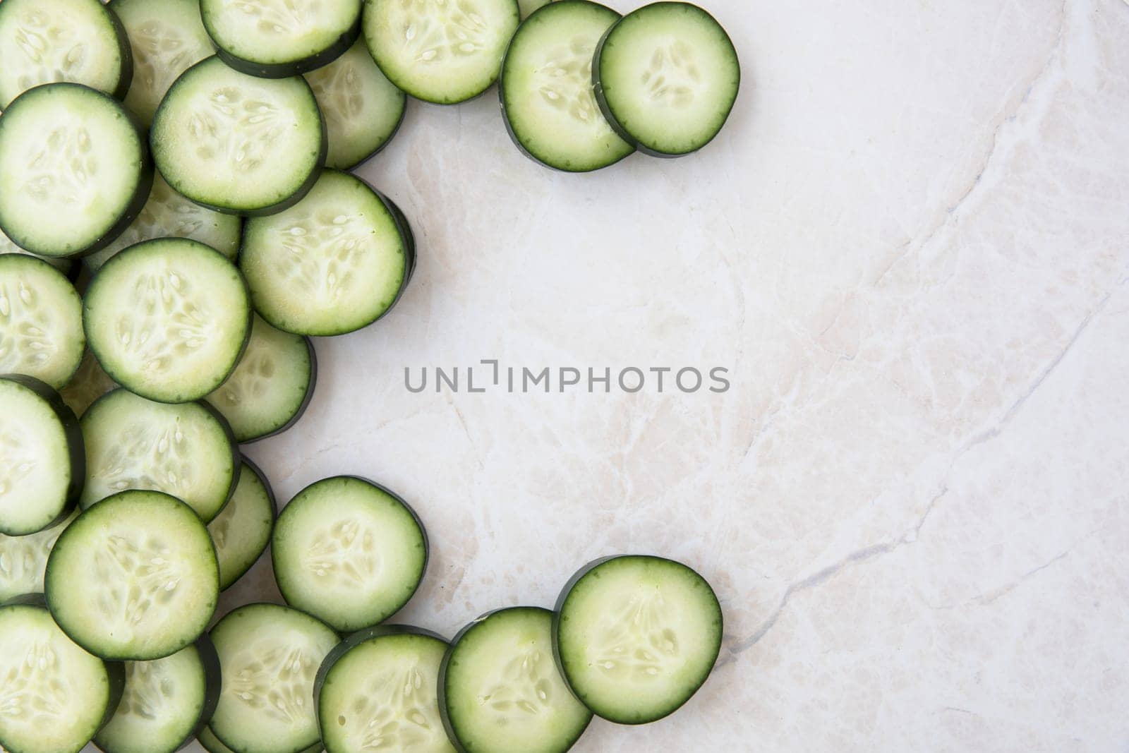 Cucumber slices on marble, flat lay with copy space