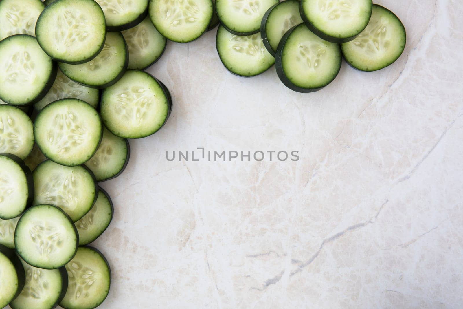 Cucumber slices on marble, flat lay with copy space