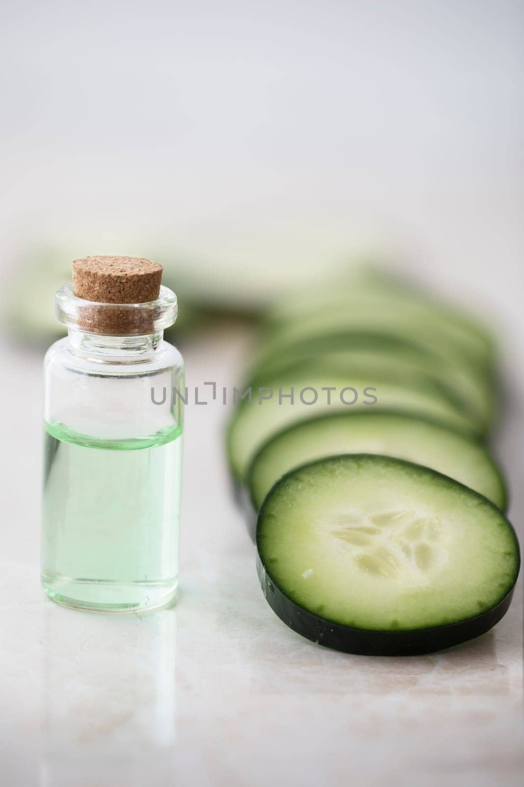 Cucumber slices and small bottle of cucumber extract.