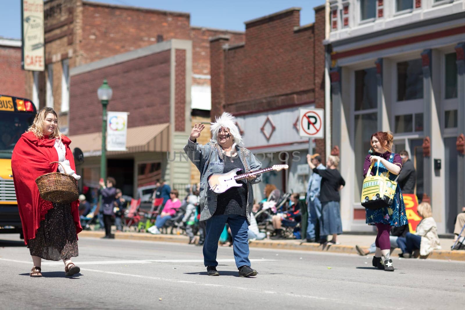 Orleans, Indiana, USA - April 28, 2018: The Orleans DogWood Festival and Parade, Woman dress up as a rocker with a toy guitar, waving at spectators during the parade