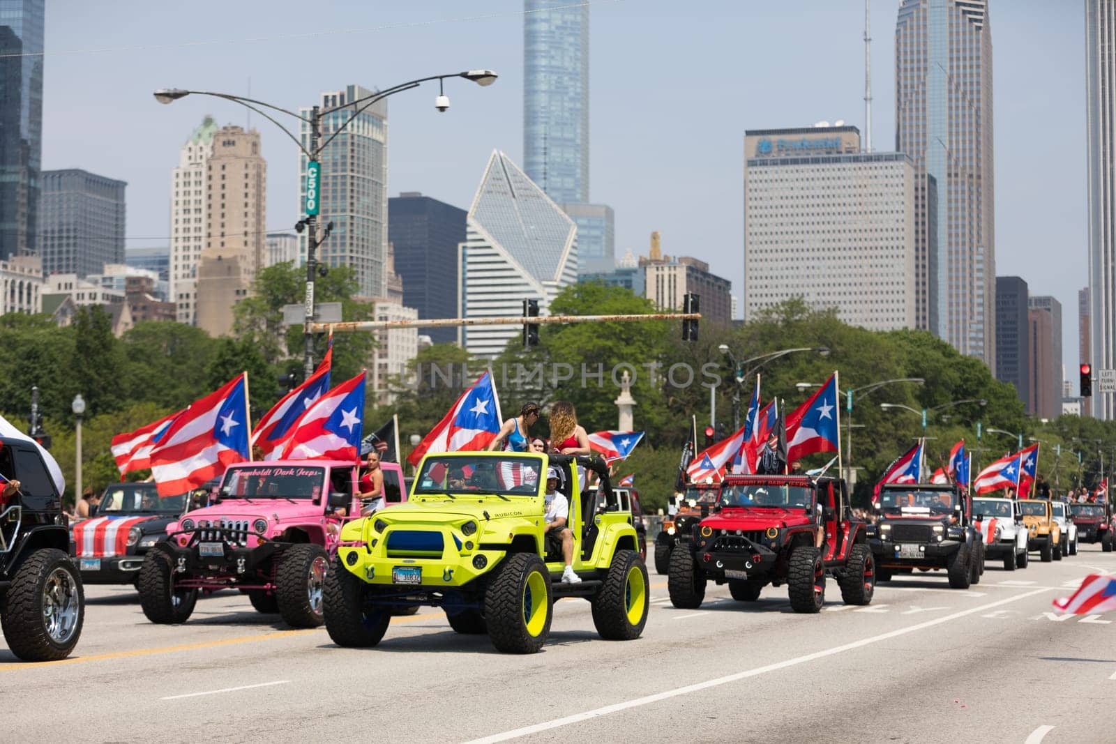 Chicago, Illinois, USA - June 16, 2018: The Puerto Rican Day Parade, Puerto Rican driving Jeeps carrying puerto rican flags during the parade