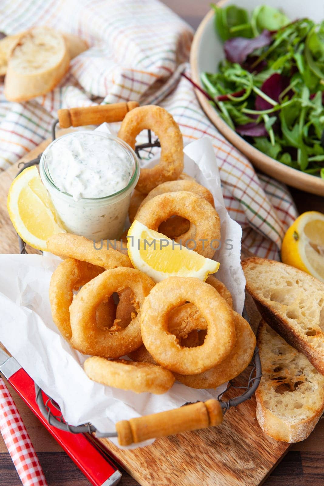 Crispy breaded calamari rings with garlic dip and lemon