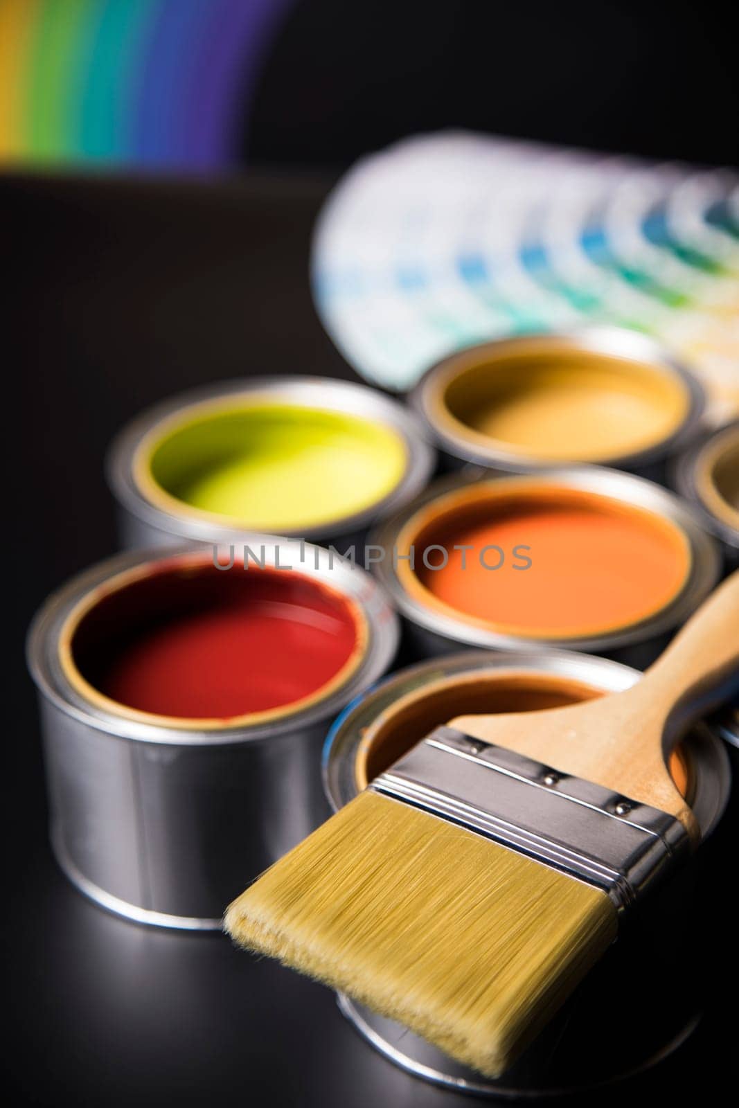 Tin cans with paint, brushes and bright palette of colors