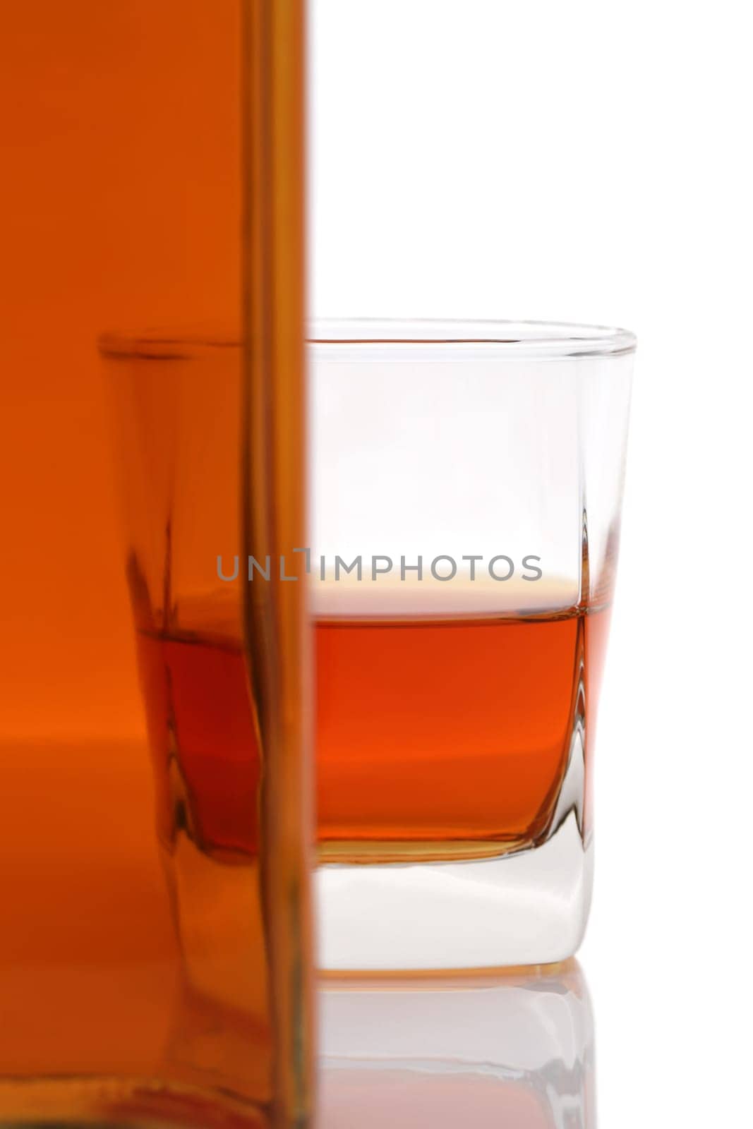 Glass cup and bottle of whiskey on white background