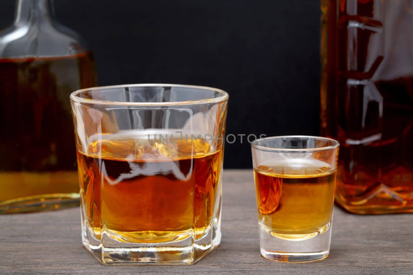 glass cup and bottle of whiskey on a old wooden table